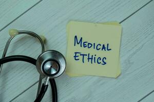 Concept of Medical Ethics write on sticky notes isolated on Wooden Table. photo