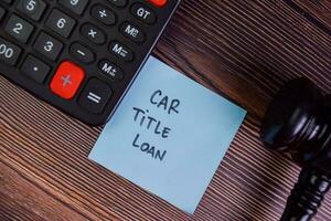 Car Title Loan write on sticky notes isolated on Wooden Table. photo