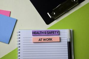 Health and Safety at Work text on top view office desk table of Business workplace and business objects. photo