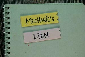 Mechanic's Lien write on a book isolated on Wooden Table. photo