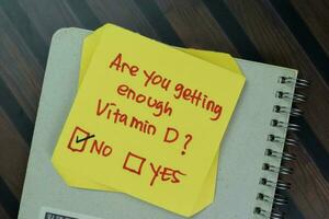 Concept of Are you getting enough Vitamin D write on sticky notes isolated on Wooden Table. photo