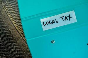 Concept of Local Tax write on the piece of paper isolated on Wooden Table. photo