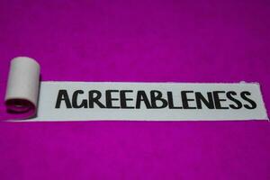 Agreeableness text, Inspiration and positive vibes concept on purple torn paper photo