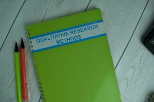 Qualitative Research Methods write on a book isolated on office desk. photo