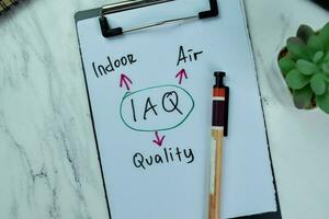 Concept of IAQ - Indoor Air Quality write on paperwork with statistics isolated on Wooden Table. photo