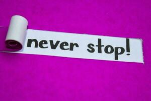 Never Stop text, Inspiration, Motivation and business concept on purple torn paper photo