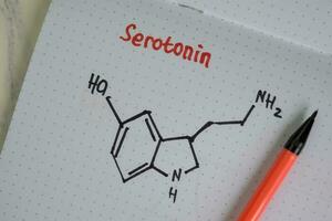 Serotonin molecule write on the paperwork. Structural chemical formula. Education concept photo