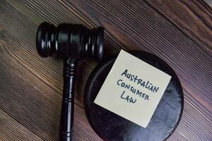 Australian Consumer Law write on sticky notes isolated on Wooden Table. photo