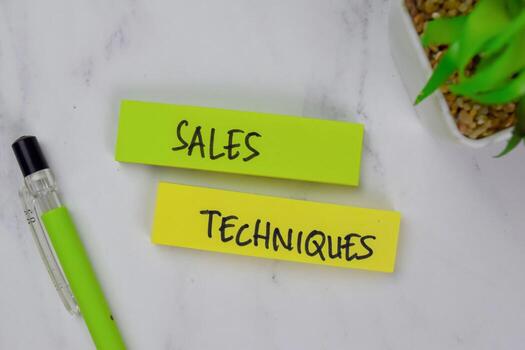 Sales Techniques write on sticky notes isolated on Wooden Table. photo