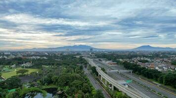 Aerial view of quiet traffic on Taman Mini street with mountain view during weekend in Jakarta city. Jakarta, Indonesia, March 8, 2022 photo