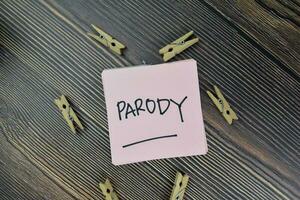 Parody write on sticky notes isolated on Wooden Table. photo