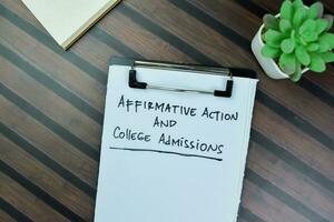Concept of Affirmative Action and College Admissions write on paperwork isolated on Wooden Table. photo