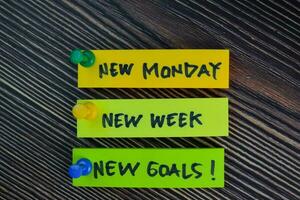 New Monday, New Week, New Goals write on sticky notes isolated on Wooden Table. photo