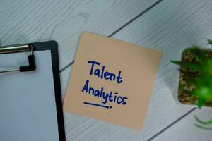Talent Analytics write on sticky notes isolated on Wooden Table. photo