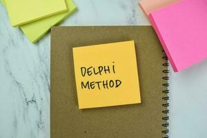 Concept of Delphi Method write on sticky notes isolated on Wooden Table. photo