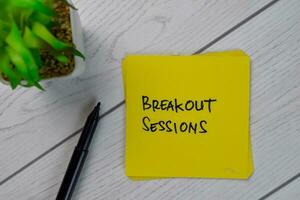 Breakout Sessions write on sticky notes isolated on Wooden Table. photo