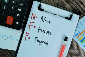 Concept of NFP - Non Farm Payroll write on paperwork isolated on Wooden Table. photo