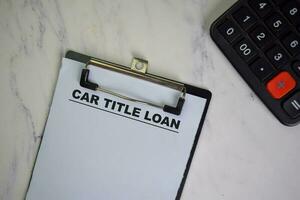 Car Title Loan write on a paperwork isolated on Wooden Table. photo