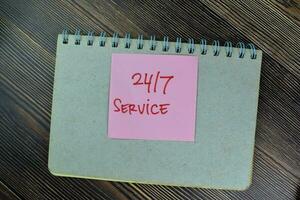 Concept of 24 7 Service write on sticky notes isolated on Wooden Table. photo