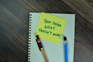 Concept of Stop Doing What Doesn't Work write on sticky notes isolated on Wooden Table. photo