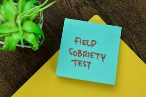 Concept of Field Sobriety Test write on sticky notes isolated on Wooden Table. photo