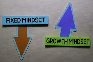 Fixed Mindset and Growth Mindset text on sticky notes isolated on office desk photo