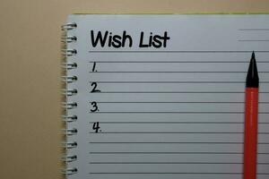 Wish List write on a book isolated on office desk. photo