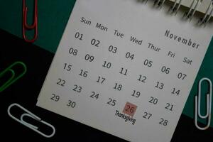 Top view November monthly Calendar and marked 26th Thanksgiving day isolated on office desk photo