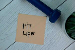 Fit Life write on sticky notes isolated on Wooden Table. photo