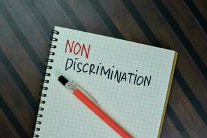 Change of Discrimination to Non-Discrimination write on a book isolated on Wooden Table. photo