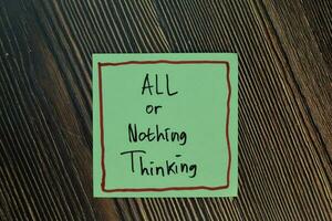 All or Nothing Thinking write on sticky notes isolated on Wooden Table. photo