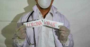 A Doctor wears a health mask and a poke paper corona virus isolated on white background. photo