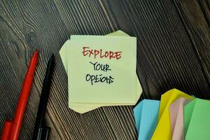 Explore Your Options write on sticky note isolated on Wooden Table. photo