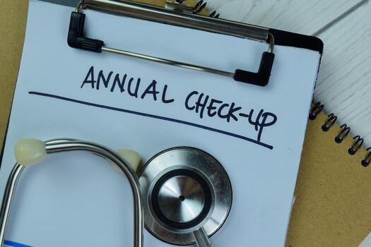 Annual Check-up write on a paperwork isolated on Wooden Table. photo