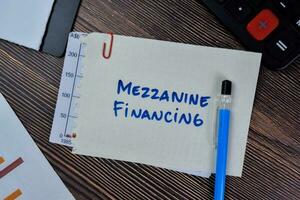 Concept of Mezzanine Financing write on sticky notes isolated on Wooden Table. photo