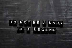 Don't be a lady. Be a legend on wooden blocks. Education, Motivation and inspiration concept photo