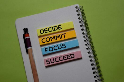 Decide. Commit. Focus. Succeed write on a sticky note isolated on office desk. photo