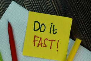 Do it Fast write on sticky notes isolated on Wooden Table. photo