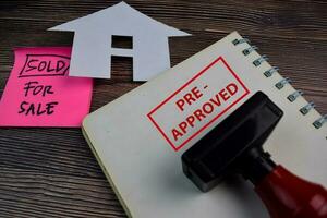 House For Sale write on a book and Red Handle Rubber Stamper Pre-Approved text isolated on the table. photo