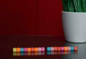 Marketing Strategis text at colorful wooden block on red background. Desk office and education concept photo