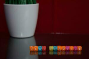 Best Practice text at colorful wooden block on red background. Desk office and education concept photo