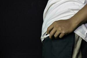 Hand of asian man holding cigarettes with black background. Smoking cigarettes concept photo