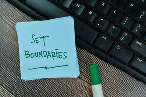 Set Boundaries write on sticky notes isolated on Wooden Table. photo