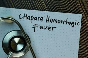 Chapare Hemorrhagic Fever write on a book isolated on Wooden Table. Medical or Healthcare concept photo