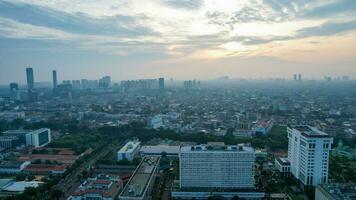 Aerial view of office buildings in Jakarta central business district and noise cloud when sunrise. Jakarta, Indonesia, May 6, 2022 photo