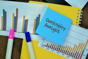 Concept of Sensitivity Analysis write on sticky notes isolated on Wooden Table. photo