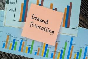 Concept of Demand Forecasting write on sticky notes isolated on Wooden Table. photo