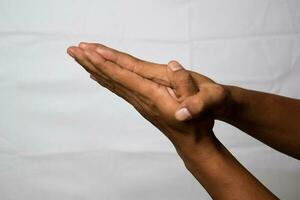 Close up Asian man shows hand gestures it means Please isolated on white background photo