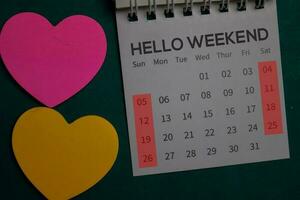 Top view Hello Weekend text on a Calendar isolated on office desk photo