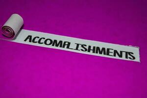 Accomplishments text, Inspiration and positive vibes concept on purple torn paper photo